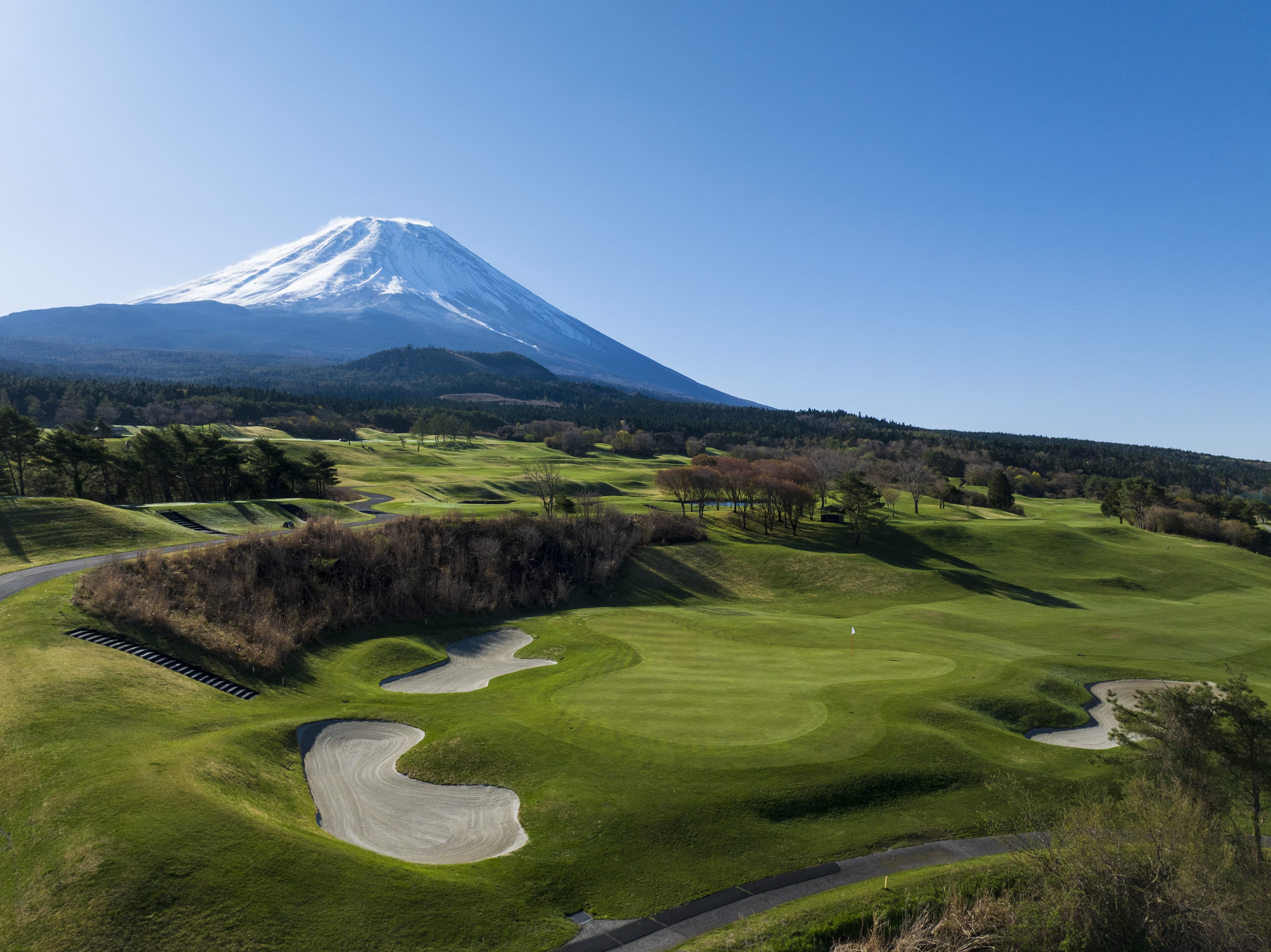 Hole 1 at Fuji Classic — bunkered green beneath snow-capped Mt. Fuji