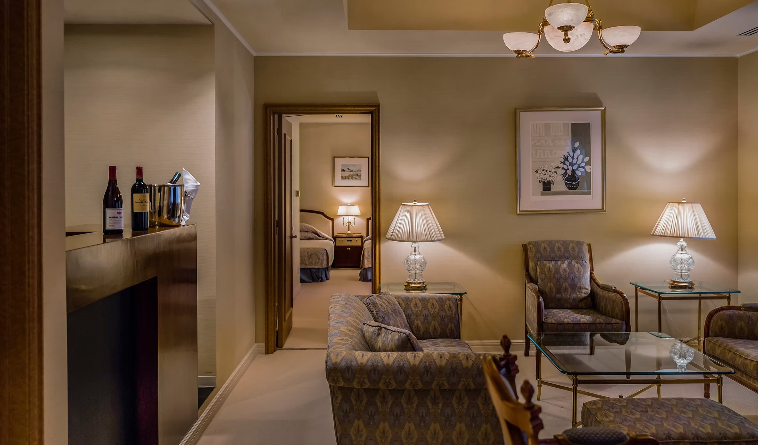 Warmly lit suite living room at Fuji Classic Hotel with classic armchairs, lamps and an adjoining bedroom