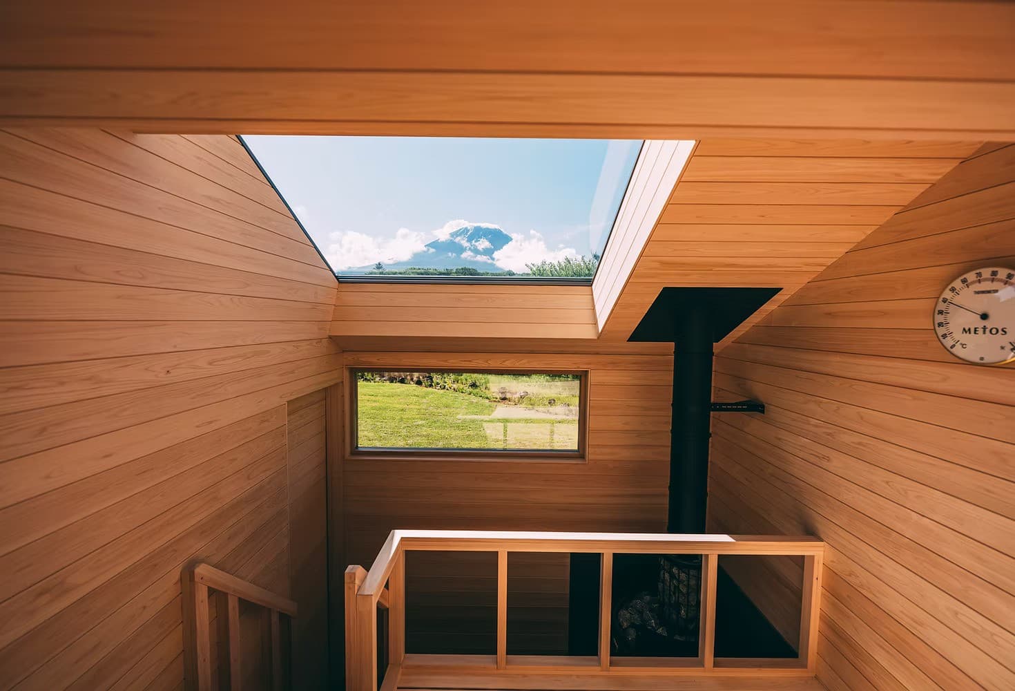 Cedar-clad interior of the GEN. private sauna villa, with Mount Fuji framed in the skylight above the stove