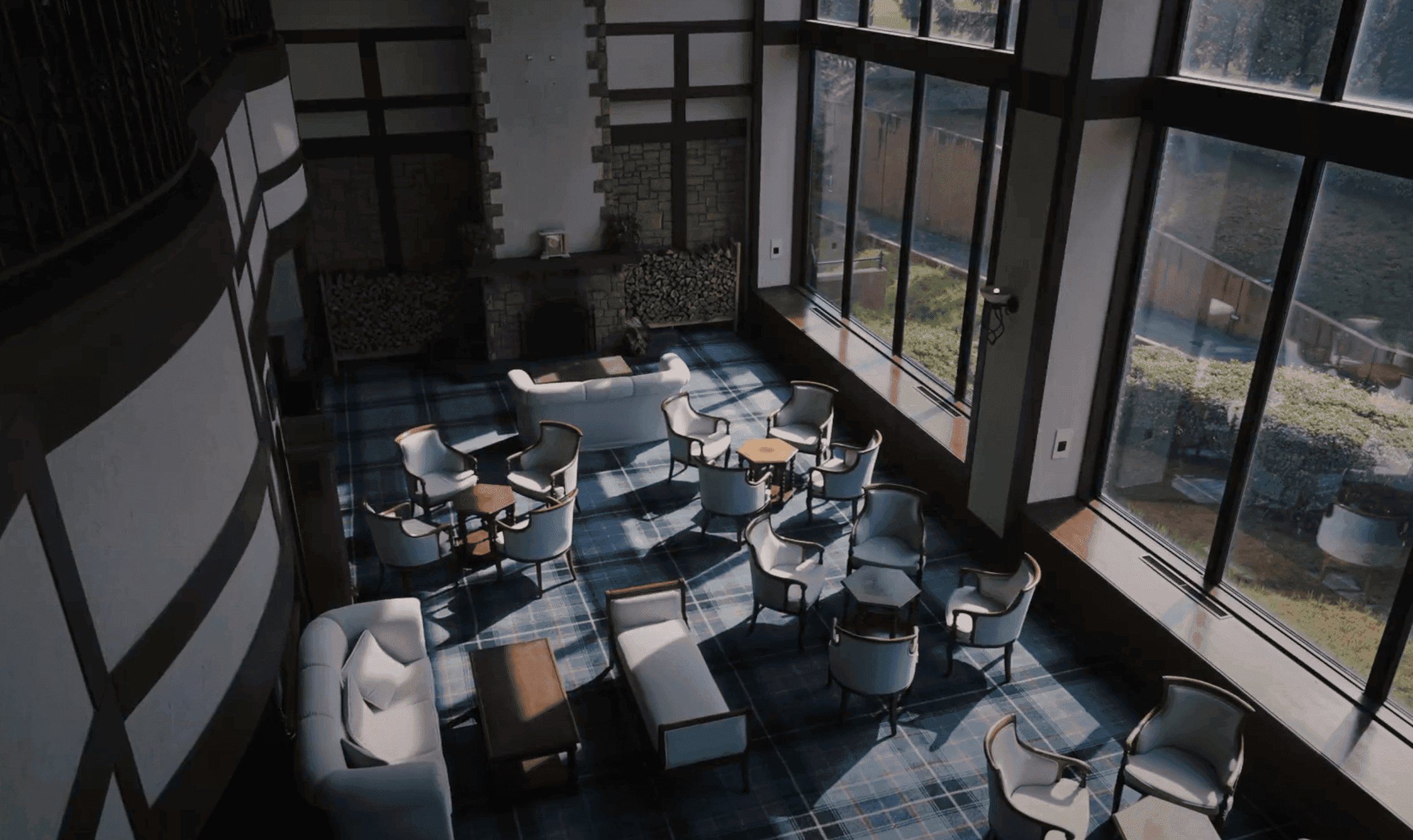 Clubhouse lounge with tartan carpet, armchairs and tall windows looking onto the course