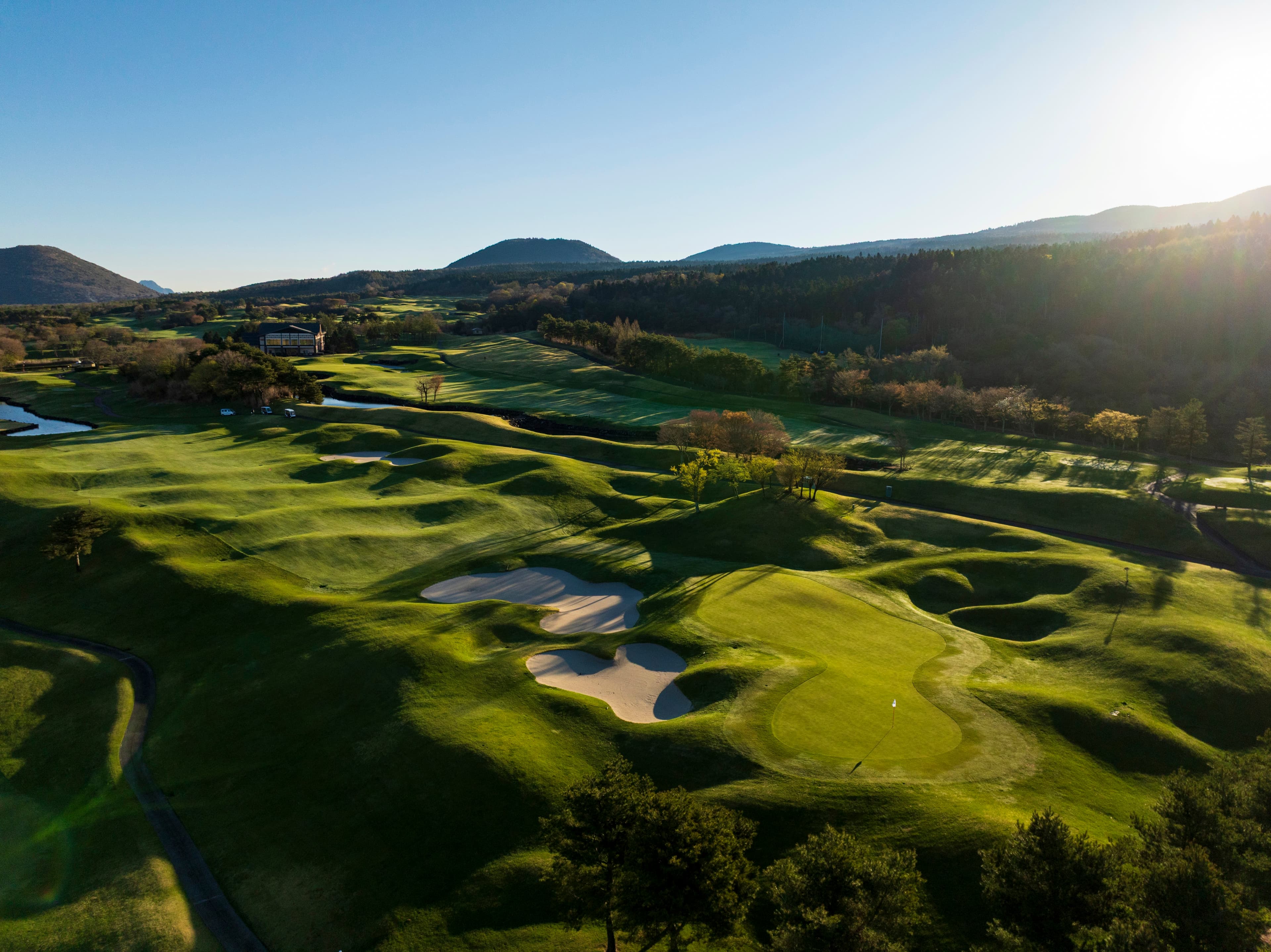 Sunlit aerial view of the rolling fairways and bunkers of Fuji Classic