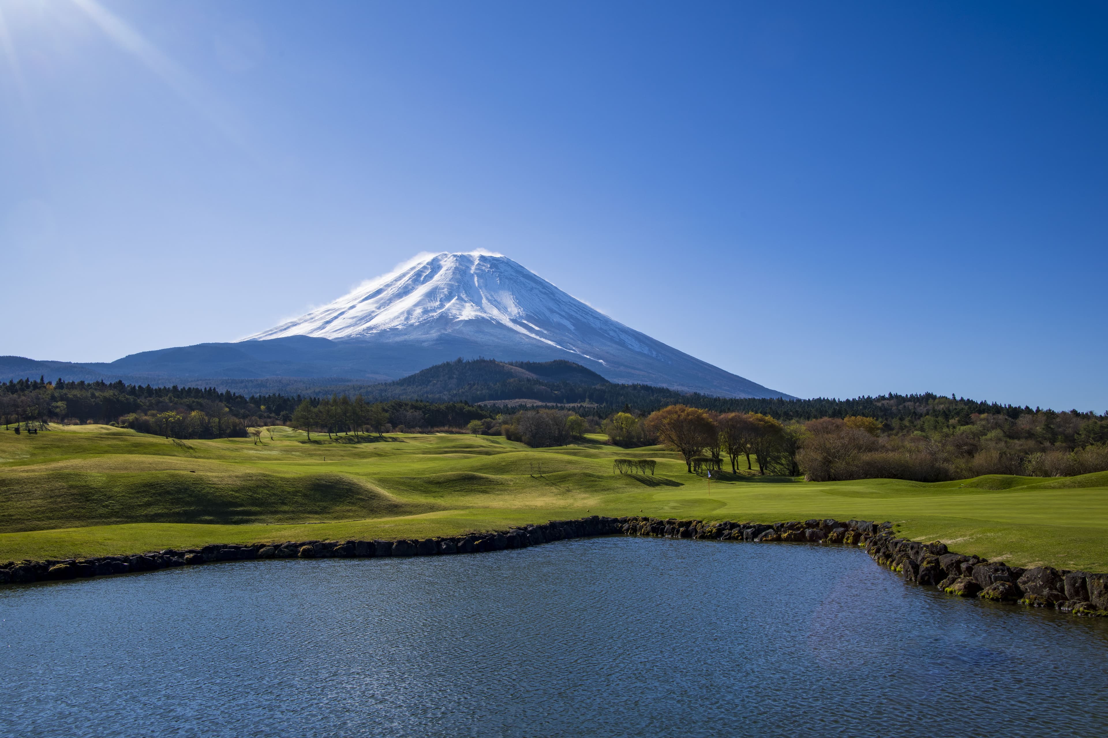 Mount Fuji towering over a pond beside the fairway